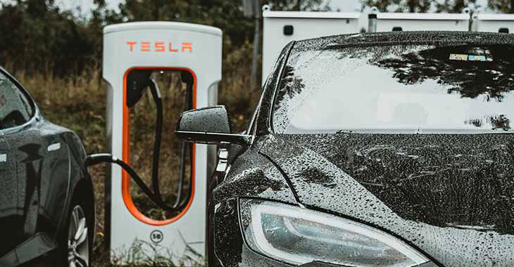 Crni automobil na punjenju na Tesla električnom punjaču