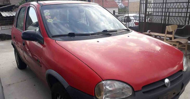 Crvena Opel Corsa B na parkingu bočni pregled