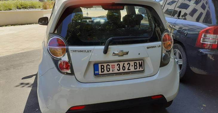 Zadnji prikaz belog automobila Chevrolet Spark